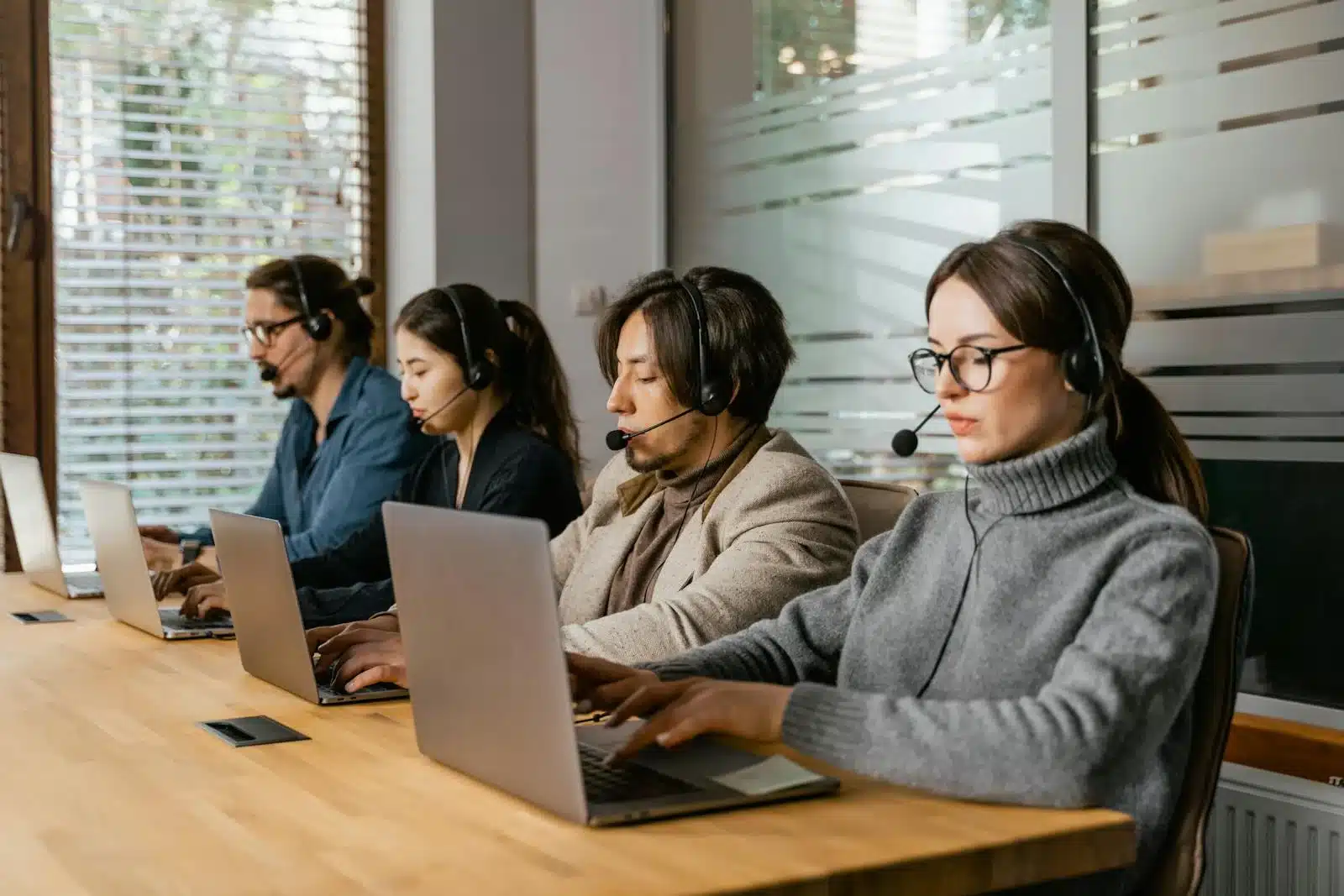 Mensen werken op laptops in een kantoor, het type werkplek waar Citrix Platform Flex zich op richt.